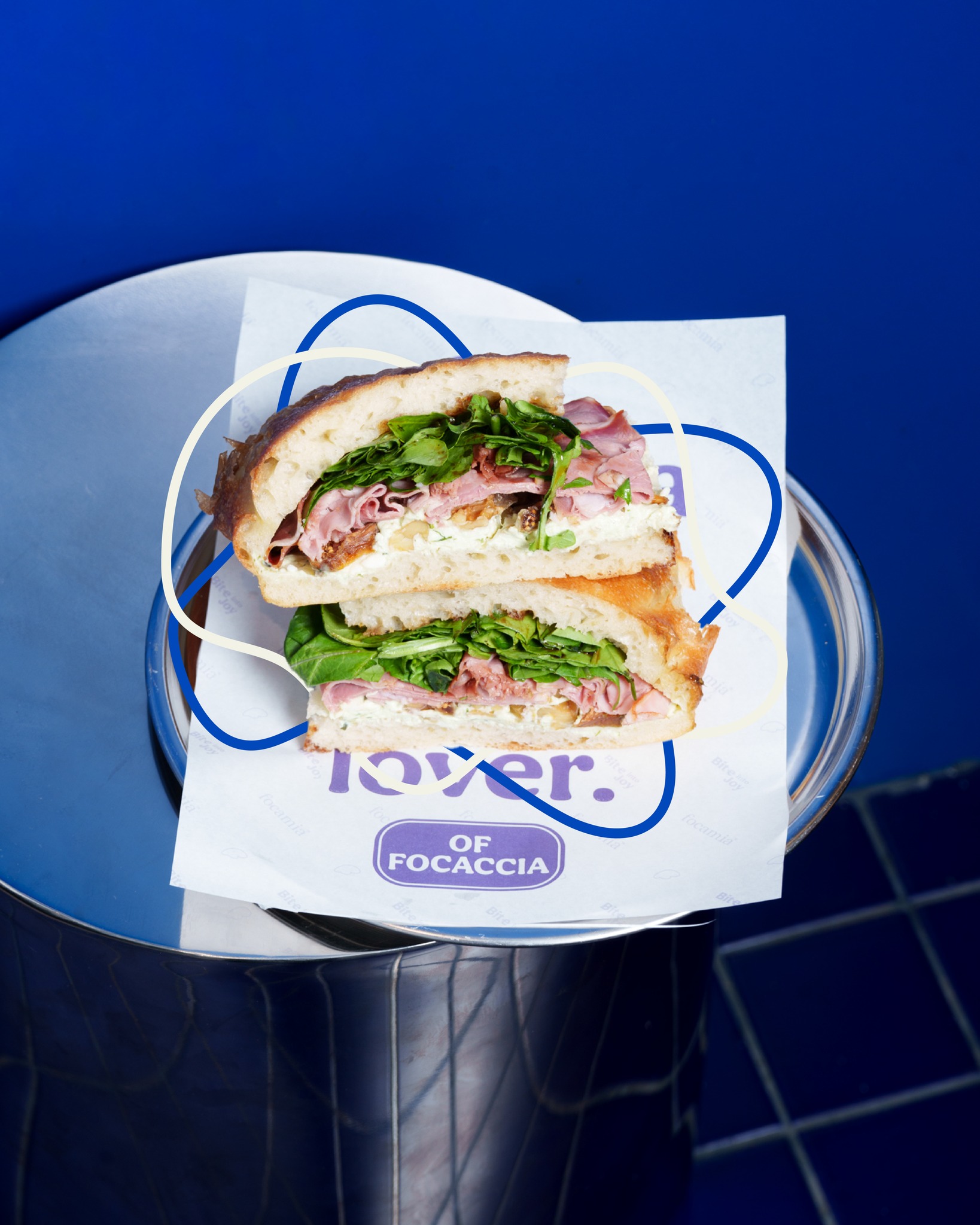Focamia focaccia sandviç — ince dilimlenmiş et, taze roka ve labne