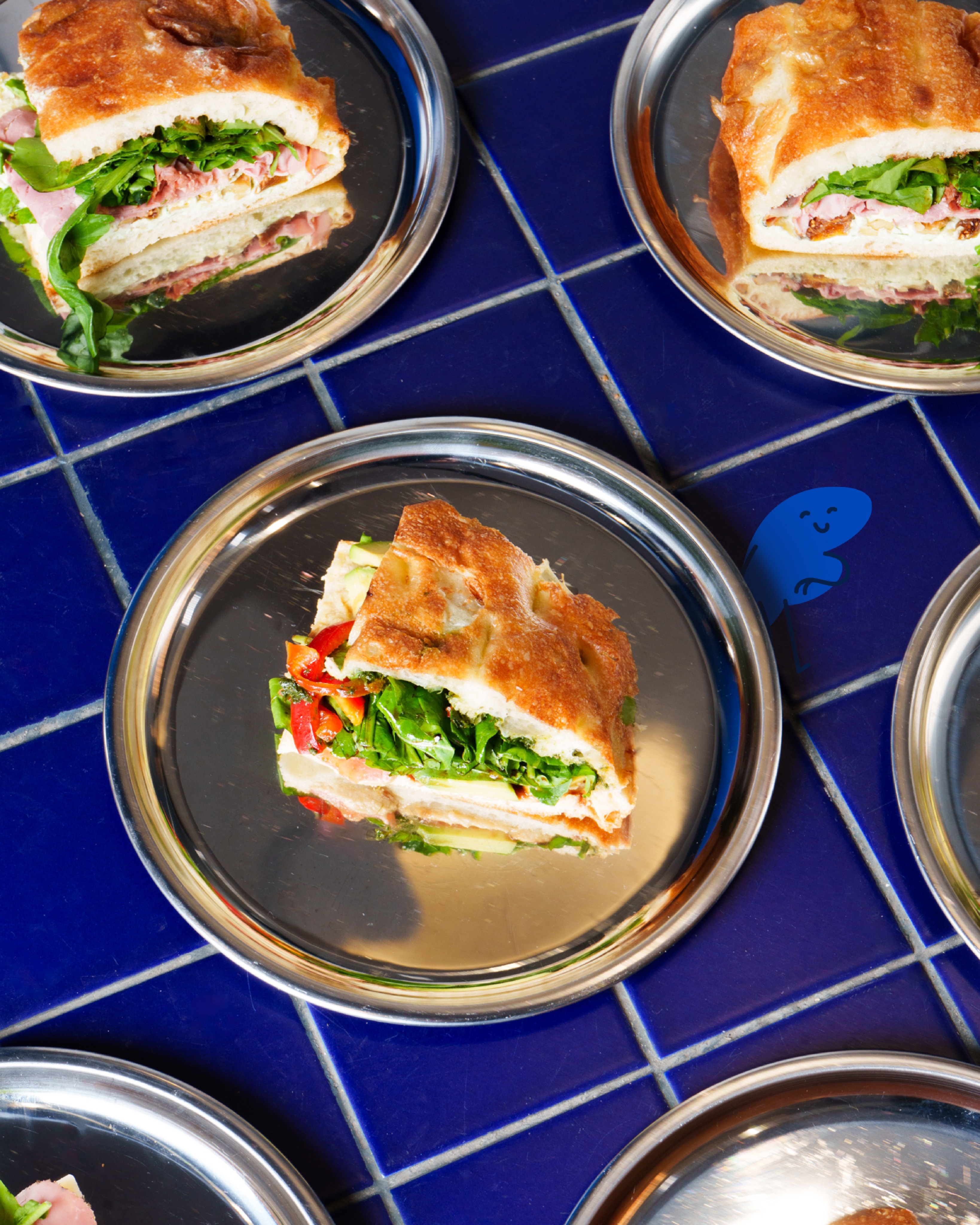 Çelik tabaklarda servis edilen focaccia dilimleri